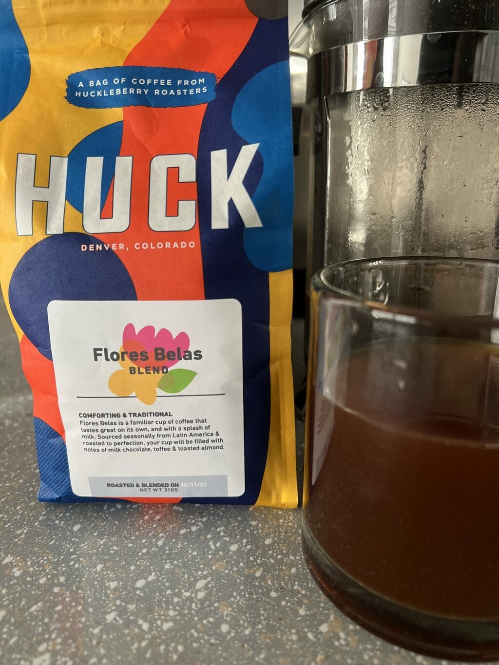 a pack of Huck Coffee next to a French press